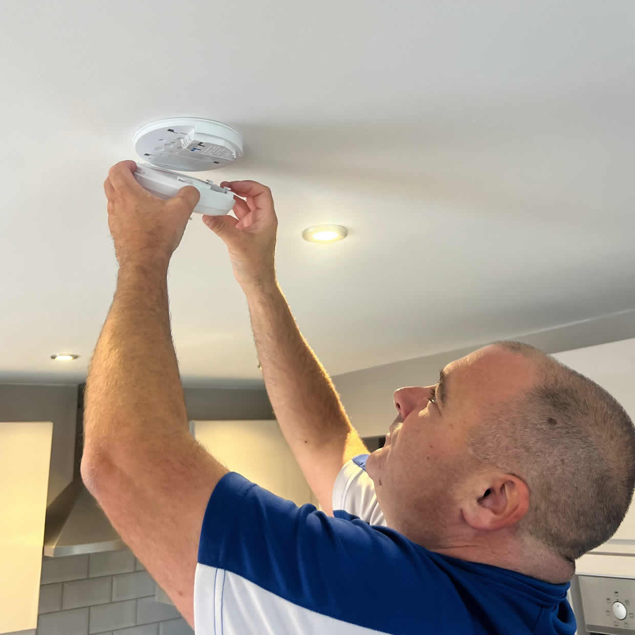 Smoke alarm installer fitting an alarm in a Bridgwater property